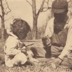 Chickahominy children cracking walnuts with stone mortar and pounder